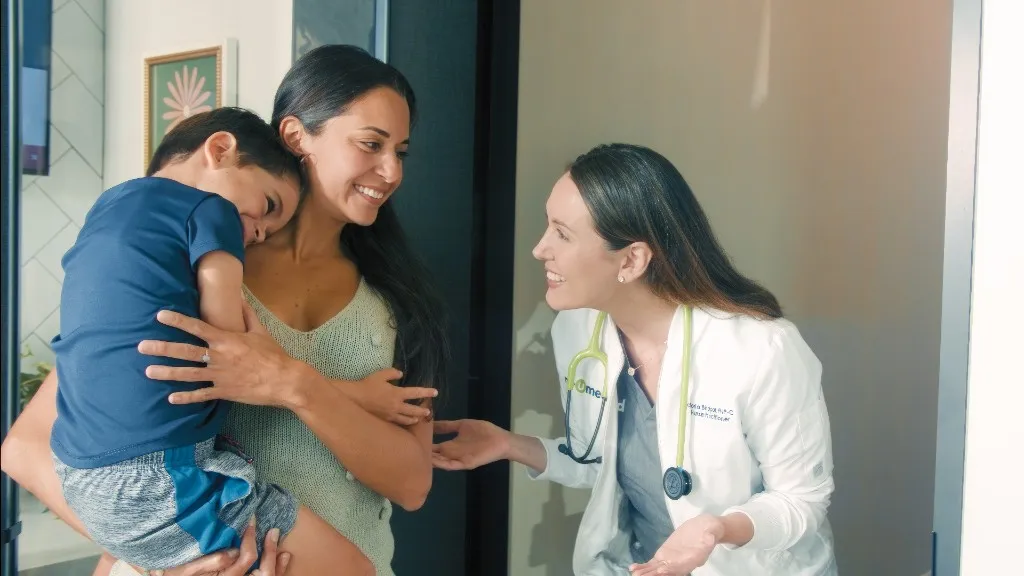 A NeuMed nurse practitioner talking with a mother and son in clinic