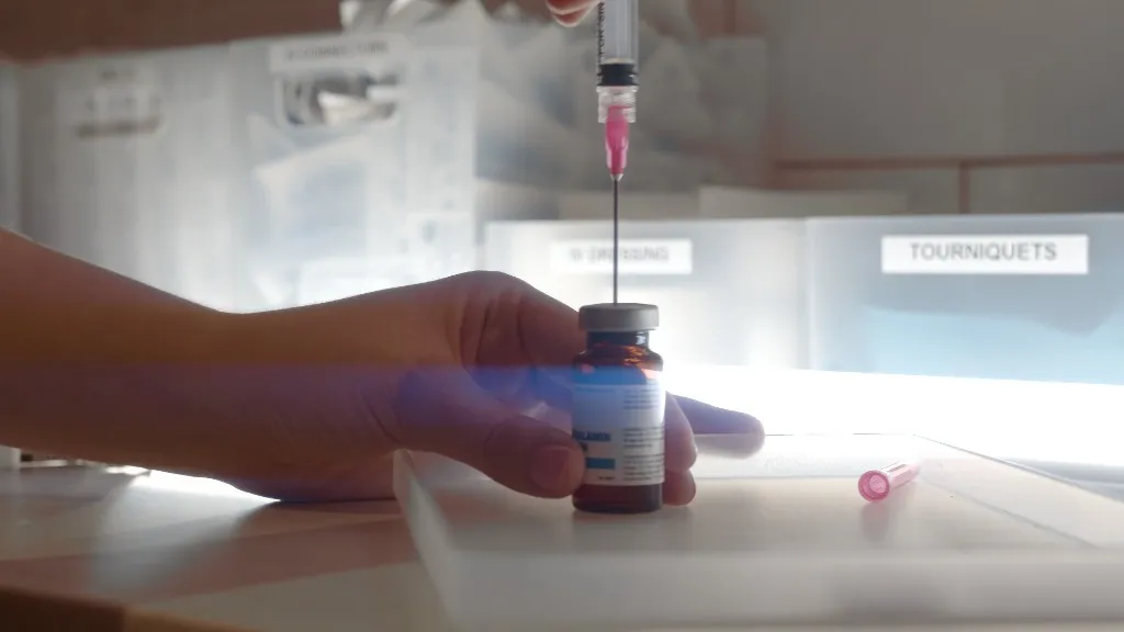 Clinician drawing vitamin B12 from a vial into a syringe