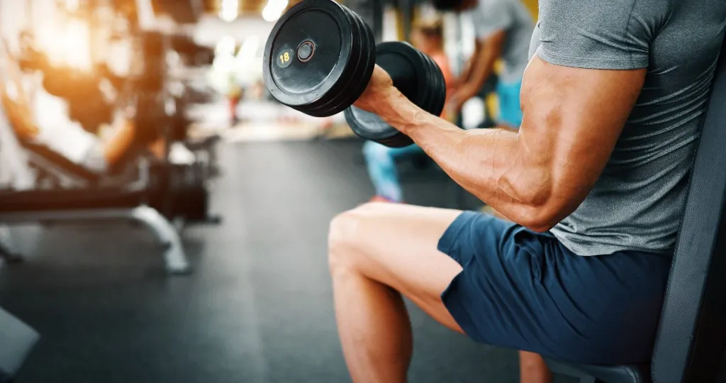 Man performing a dumbbell curl in the gym