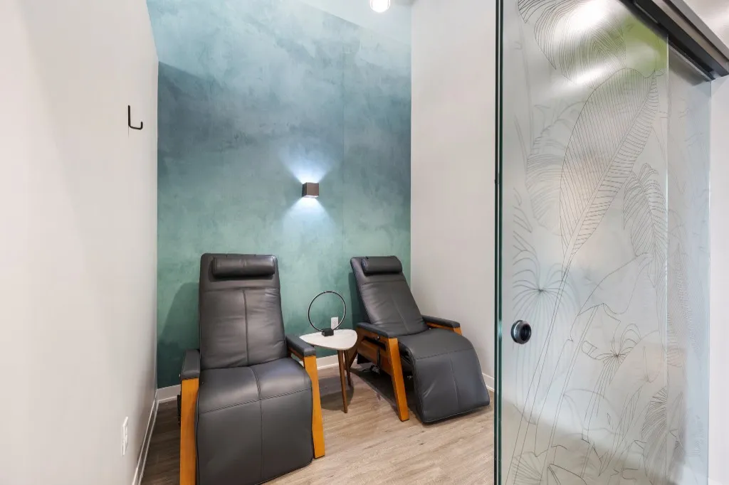 NeuMed IV suite with two recliner chairs and a teal accent wall