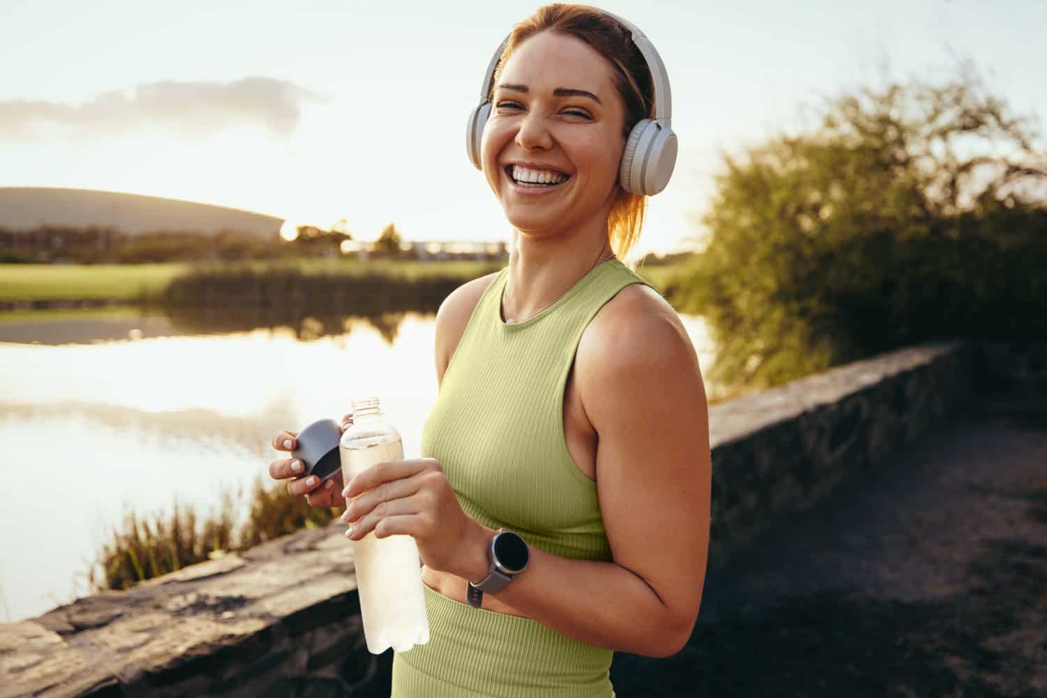 Girl Wearing Headphones Drinking Water Outside