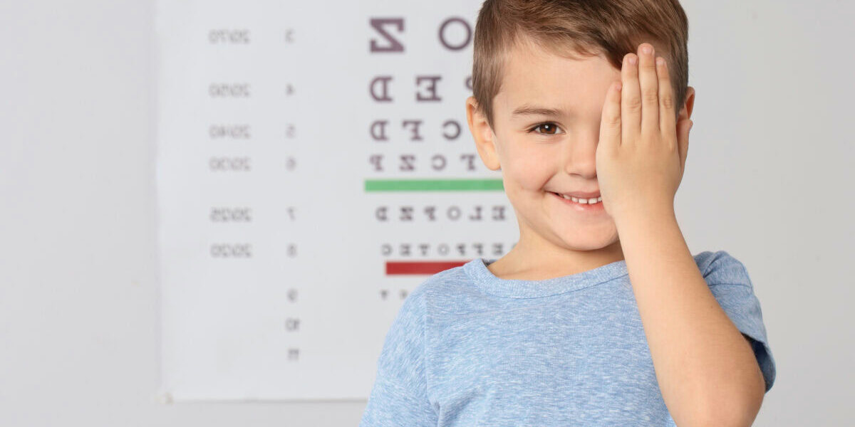 Cute little boy visiting children's doctor, space for text. Eye examination