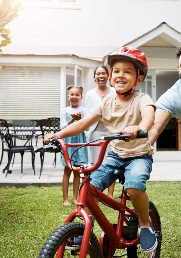 Father helping son ride bike outside Father helping son ride bike outside