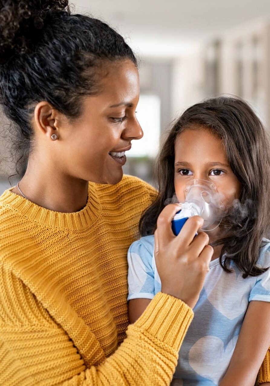 mother helping daughter with asthma inhaler square mother helping daughter with asthma inhaler square